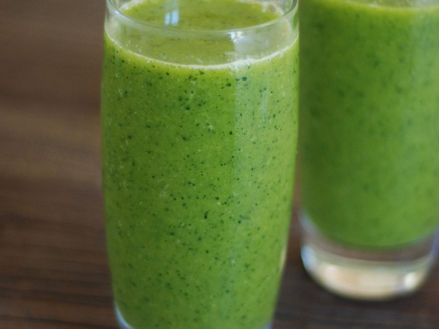 Two green smoothies on a rustic wooden table