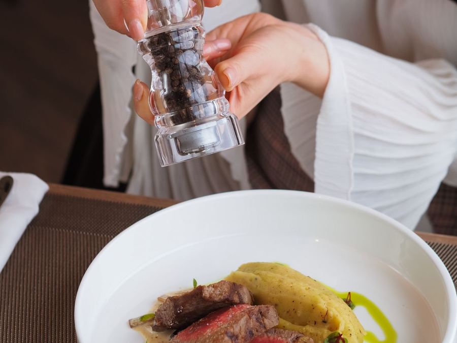 Freshly cracked pepper seasoning a plated steak