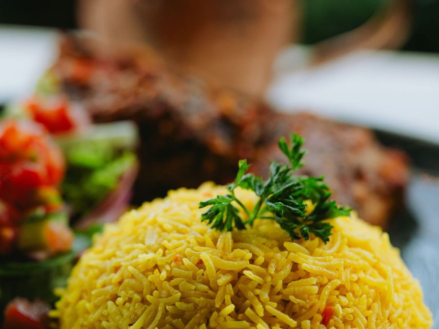 A vibrant yellow rice dish served with fresh herbs